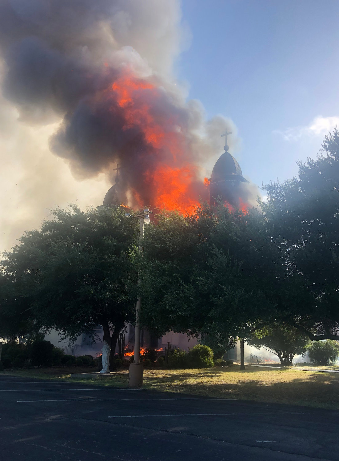 Flames and smoke billow out of the Church of the Visitation in Westphalia, Texas, July, 29, 2019. The nearly 125-year old wooden church with bell towers on each side, burned to the ground that morning. Since 1883 the parish has served the Catholic community of southwestern Falls County, many of whom are descendents of immigrants from the northwest German region of Westphalia.